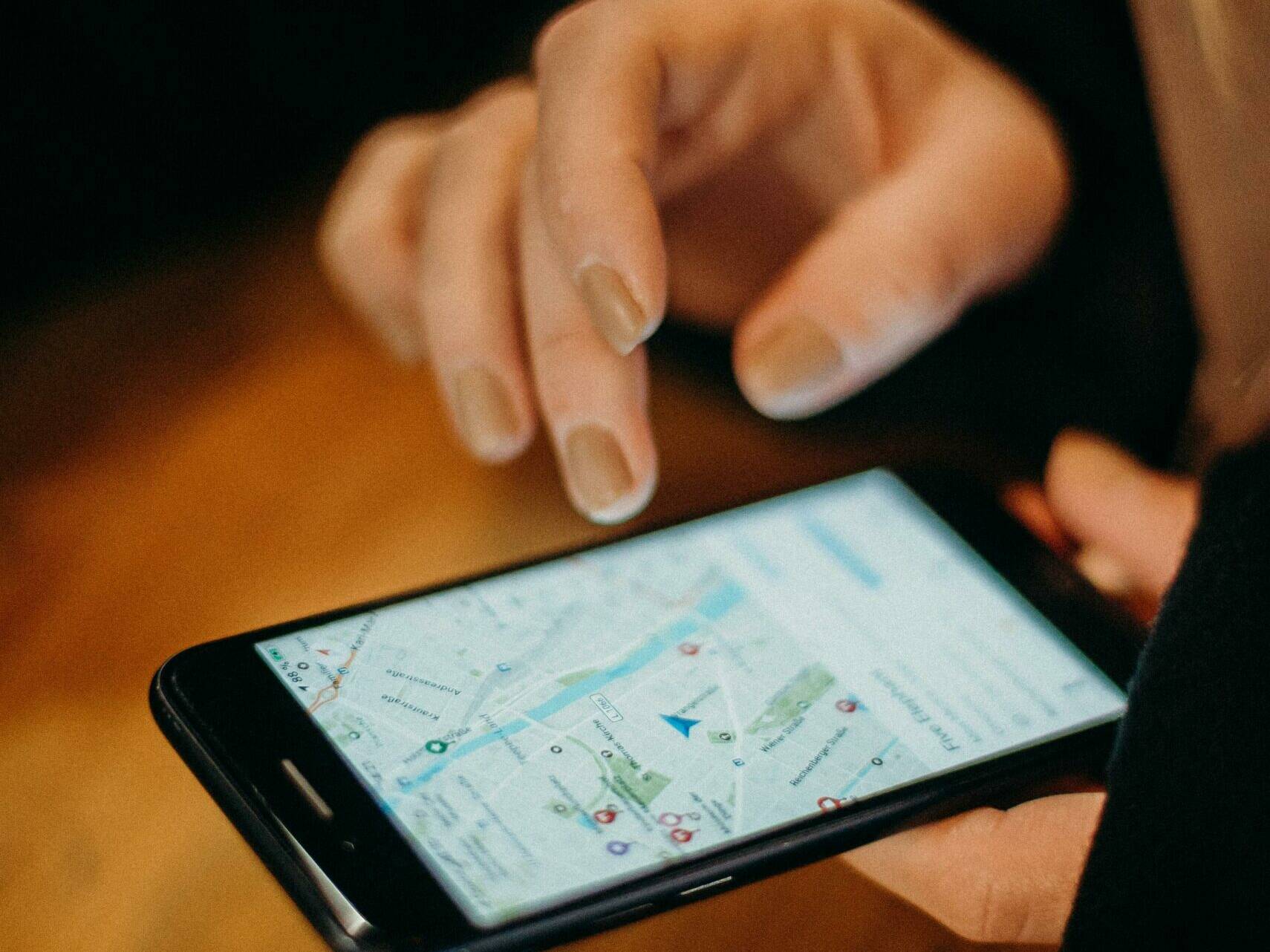 A person consulting a map on a smartphone to view a position or track a mobile asset