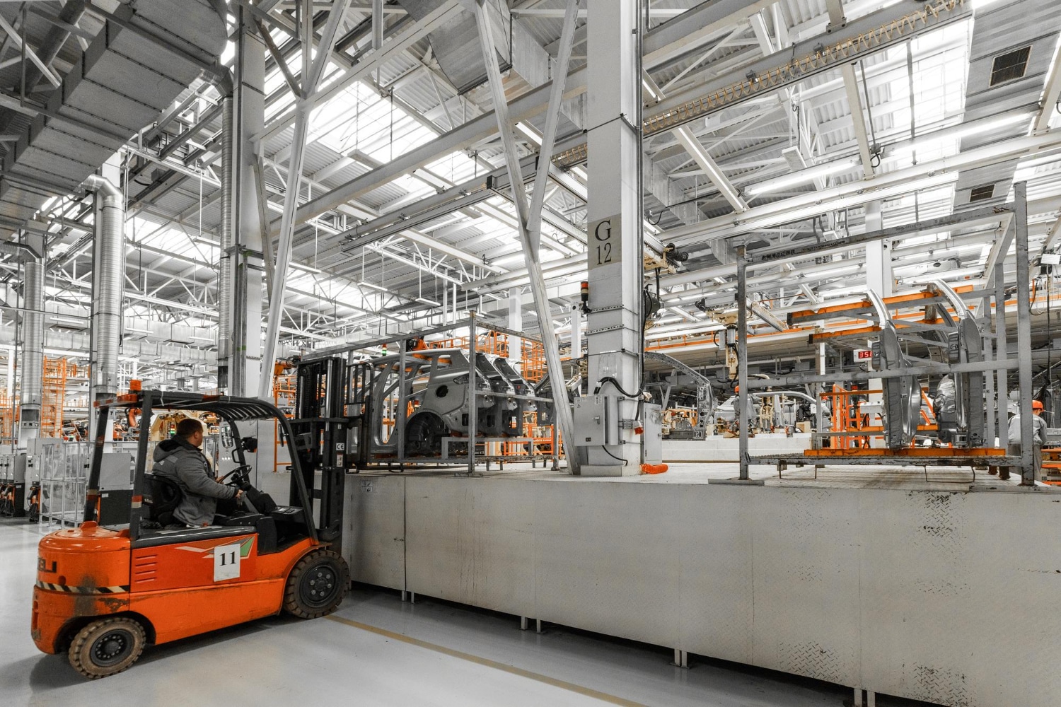 Chariot élévateur circulant dans une usine automobile équipée d’une ligne de production